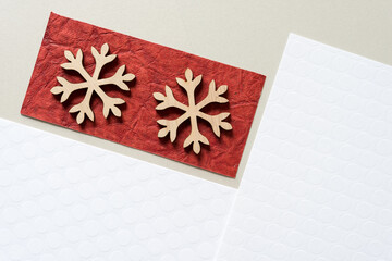 two wooden snowflakes on paper
