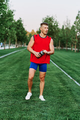 athletic man in red tank top posing outdoors fitness