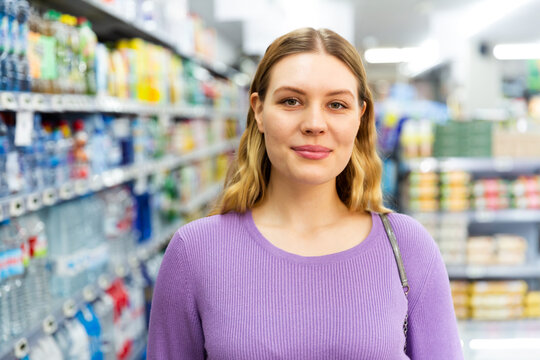 Portrait of smiling female in the modern supermarket. High quality photo