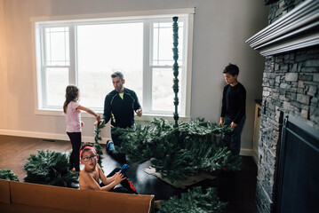 Artificial Christmas tree being decorated for winter. 