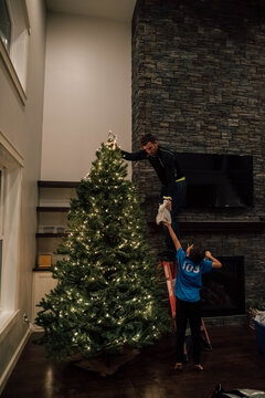 Son handing his father an angel for the tree. 