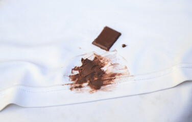 dirty choclate stain on kid shirt from eating for cleaning concept in housework clear
