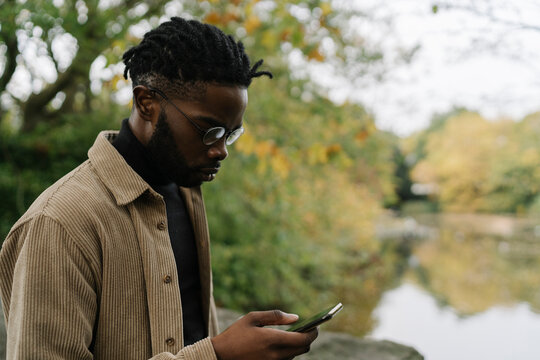 Handsome man Using a Mobile Phone in the City Park