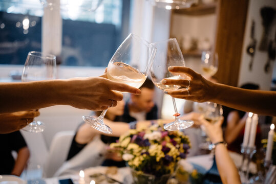 friends clink glasses with white wine