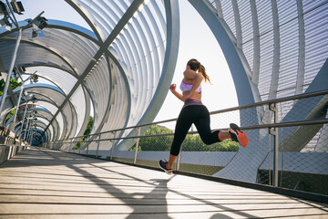 Woman running at street in sunlight 