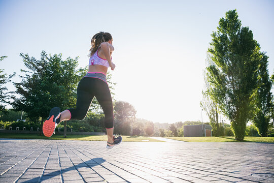 Unrecognizable woman jogging in park 
