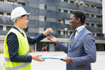 Happy architect transmits keys to the new african american businessman shopping center