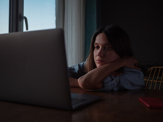Woman watch something on laptop at home in the evening