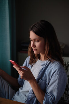 Woman scrolling on her smartphone at home
