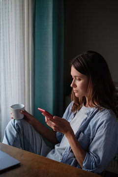 Woman scrolling on her smartphone at home