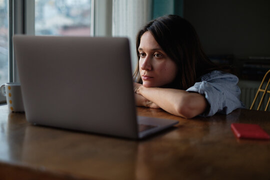 Woman watch something on laptop at home in the evening