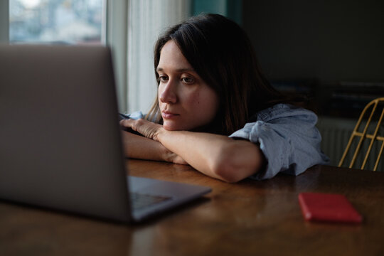 Woman watch something on laptop at home in the evening