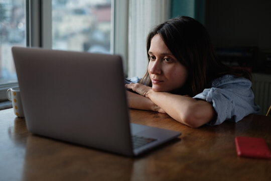 Woman watch something on laptop at home in the evening