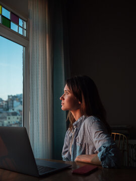 Woman with laptop at home in the evening