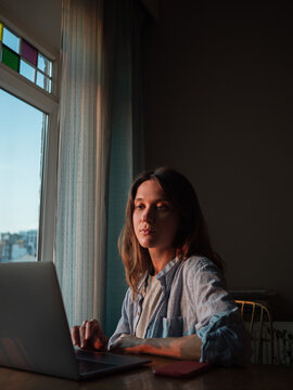 Woman working on laptop at home in the evening