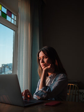 Woman working on laptop at home in the evening