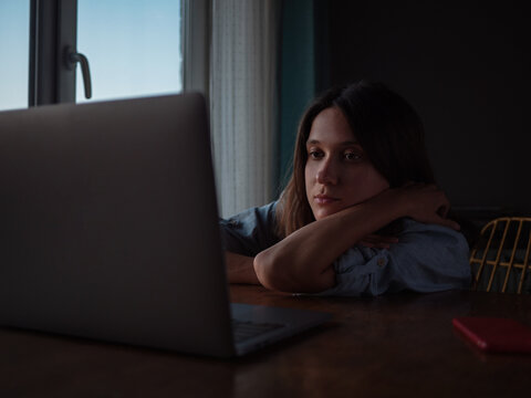 Woman watch something on laptop at home in the evening