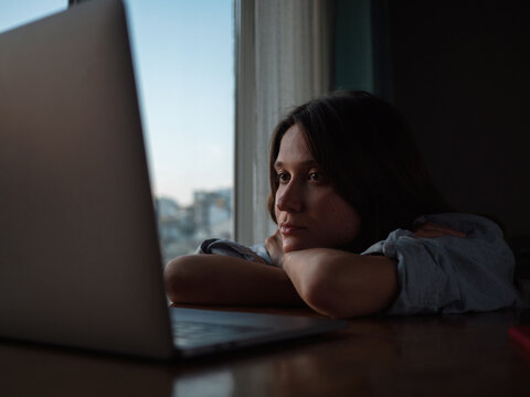 Woman watch something on laptop at home in the evening