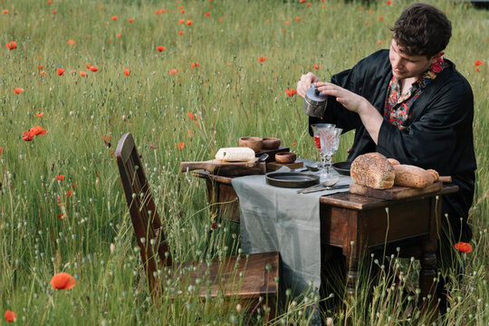 Man Pouring Italian Coffee In A Poppy Field