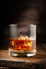 Glass with whiskey and ice cubes.