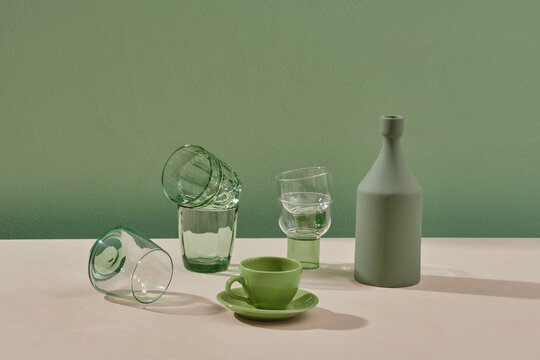 Transparent crystal glasses of different shapes on green