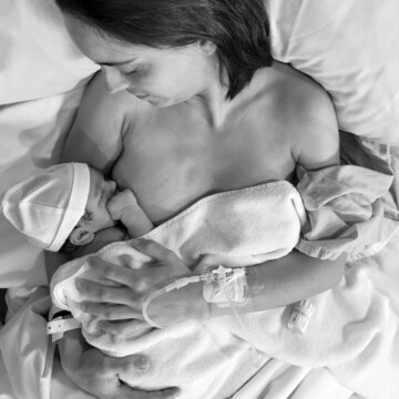 Mother Breastfeeding Newborn In Hospital