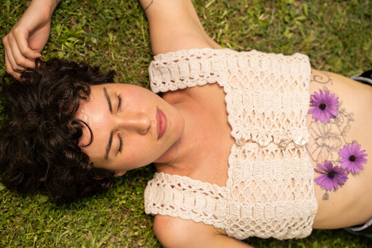 Portrait of young woman laying on grass having fun