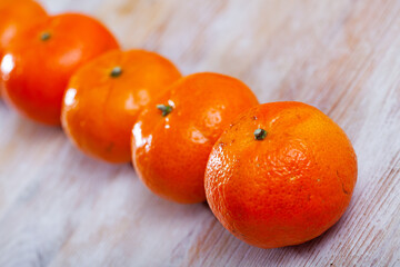 Pile of whole ripe organic clementines on wooden background.. © JackF