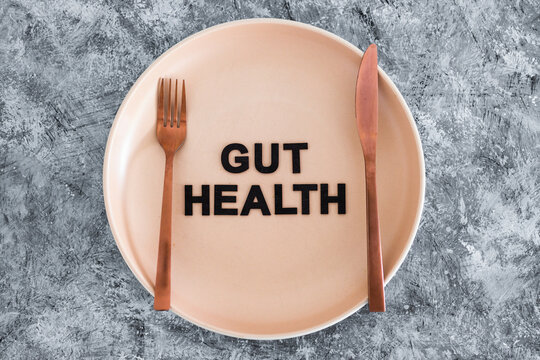 gut health text on dining plate with fork and knife, healthy nutrition and research about the microbiome