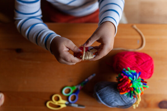Kid making colored pompons top view