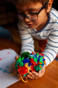 Boy holding colorful wool pompons