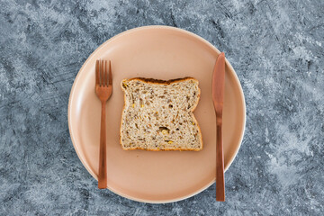 wholegrain multiseeds slice of bread on dining plate with fork and knife, dieting vs healthy nutrition and intuitive eating