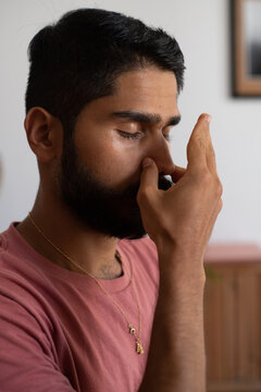 Man holding his nose during a pranayama breath practice
