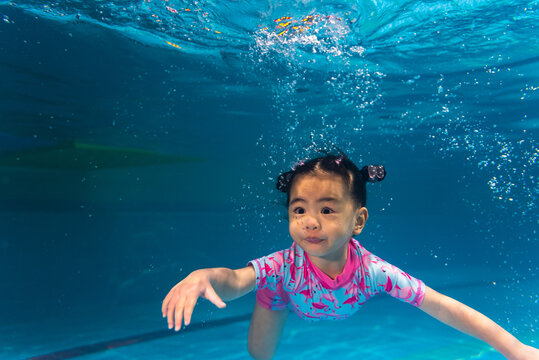swimming baby girl under water portrait
