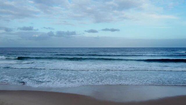 4K drone footage of Mollymook beach at dusk heading out to sea