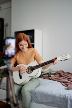 Woman studying play on musical instrument at home