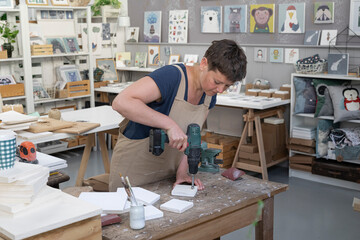 Young Artist Drilling Holes Into Canvas 