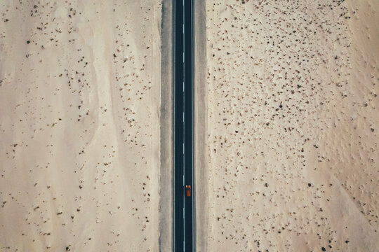 Vehicle on road between sandy terrain
