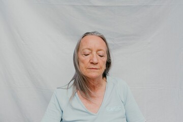 Senior woman over white background and eyes closed