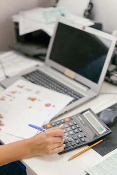 Business woman using calculators at work.