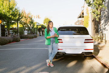 Businesswoman browsing smartphone near car
