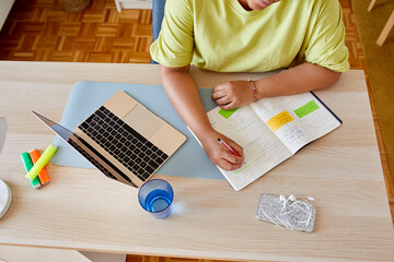 Woman with planner and laptop working at home