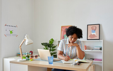 Black woman taking notes in notebook