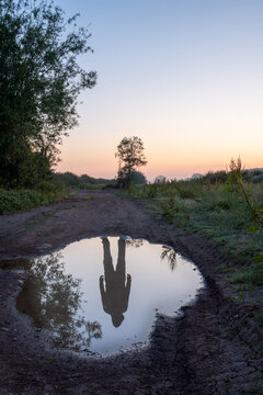 A ghostly figure reflected in a puddle.