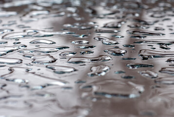 Water Puddles on Reflective Glass Surface