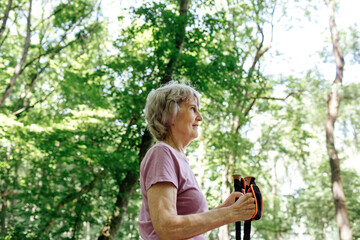 Active senior woman trekking in forest