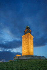 Tower of Hercules at sunset in A Coruña with the tower illuminated. photo taken in the blue hour with a tilt-shift lens.