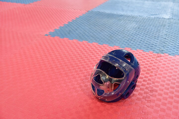 Taekwondo head guard for children on a training mat with copy space