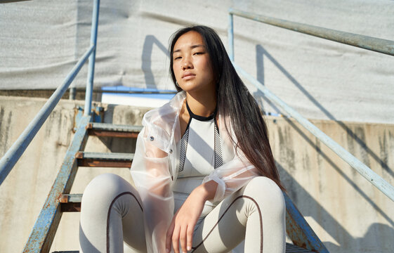 Young woman in sporty outfit sitting on stairs