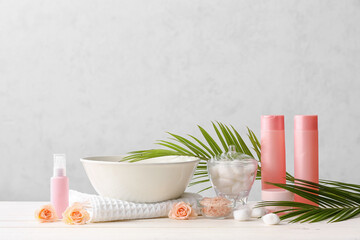 Spa set with bowl of water on light background